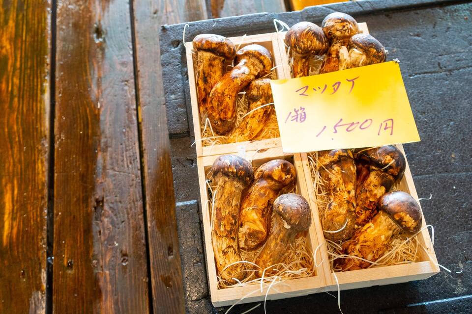 A wooden crate filled with mushrooms on a wooden surface.