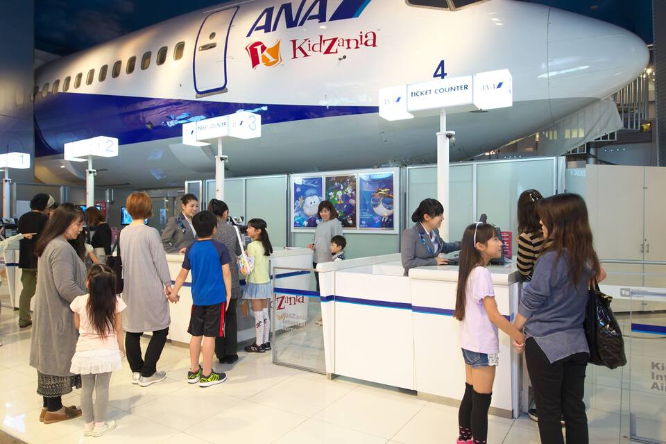 Una taquilla d'entrades a l'Aeroport de KidZania amb un model d'avió gran a la part superior.