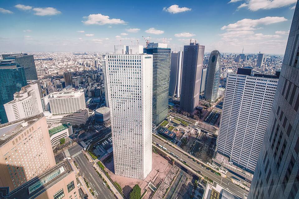 A cityscape with tall buildings, a clear sky, and a distant view of a city skyline.