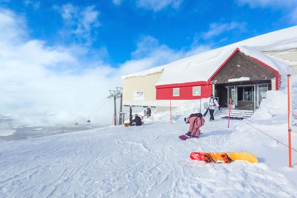 Preparing to go snowboarding in front of a cable car station (Niseko, Hokkaido, Japan)