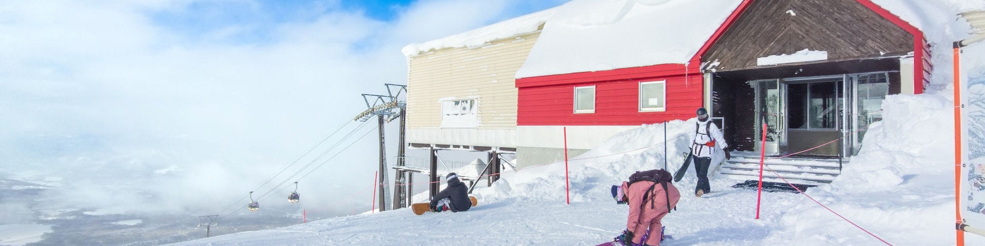 Preparing to go snowboarding in front of a cable car station (Niseko, Hokkaido, Japan)
