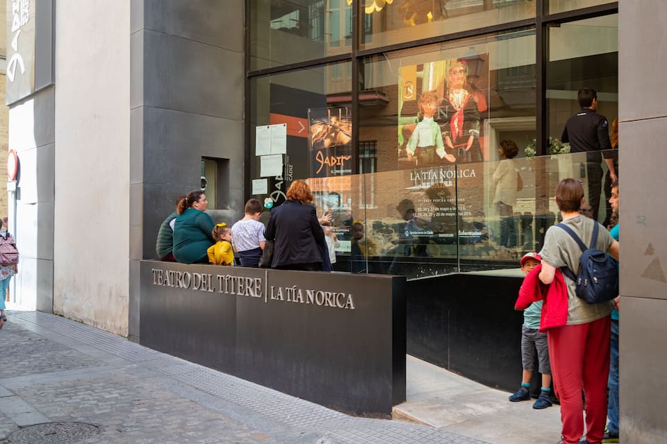Teatro Del Titire and La Tía Norica with people outside.