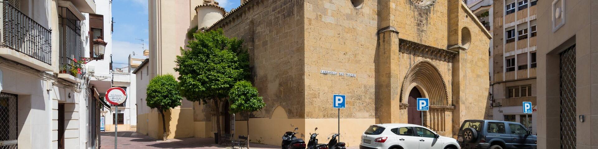 Una iglesia histórica con un campanario y un amplio ventanal circular.