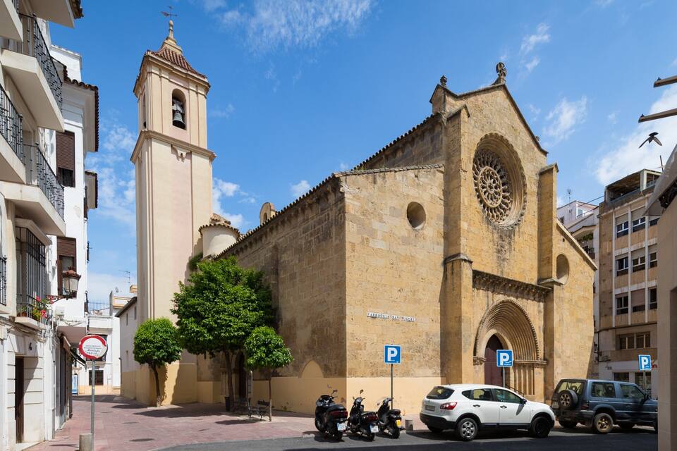A historic church with a bell tower and a large circular window.