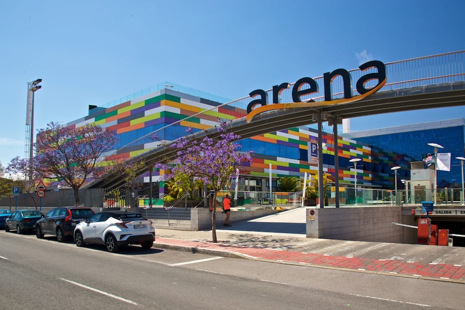 A modern building with a colorful facade and the word "arena" prominently displayed.