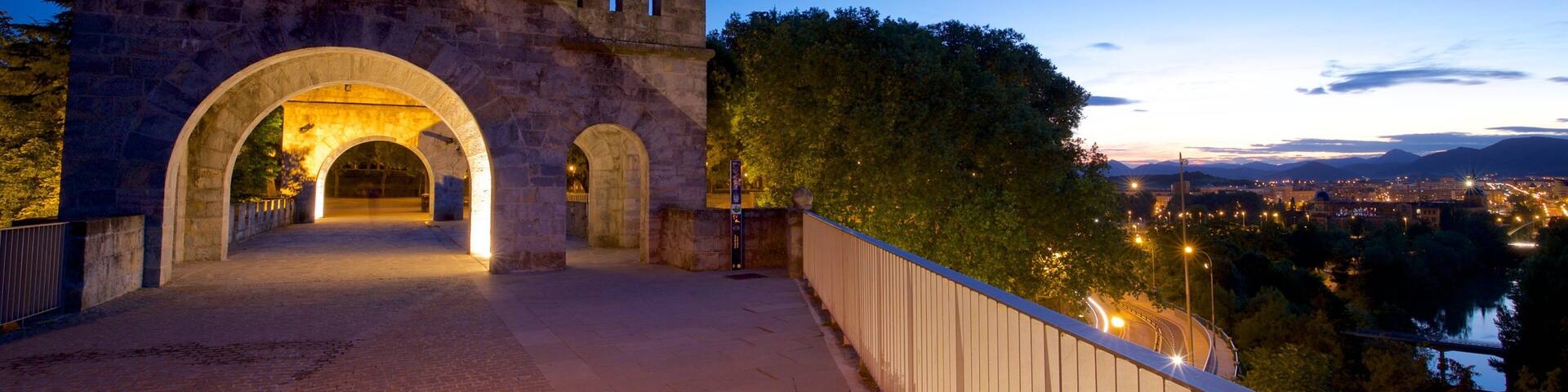 Un puente de piedra con arcos al anochecer.