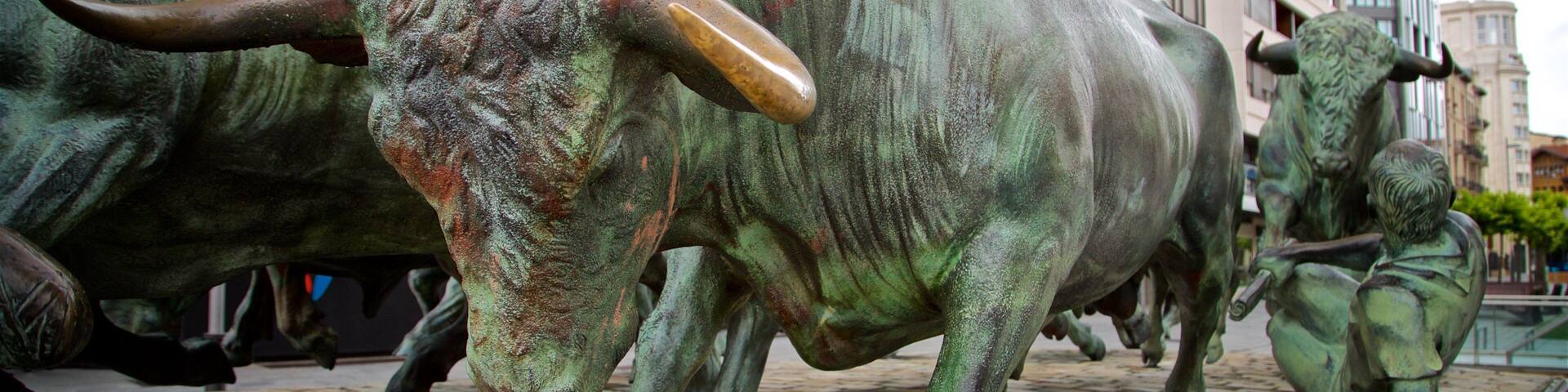 Una estatua de bronce de un toro en una calle empedrada.