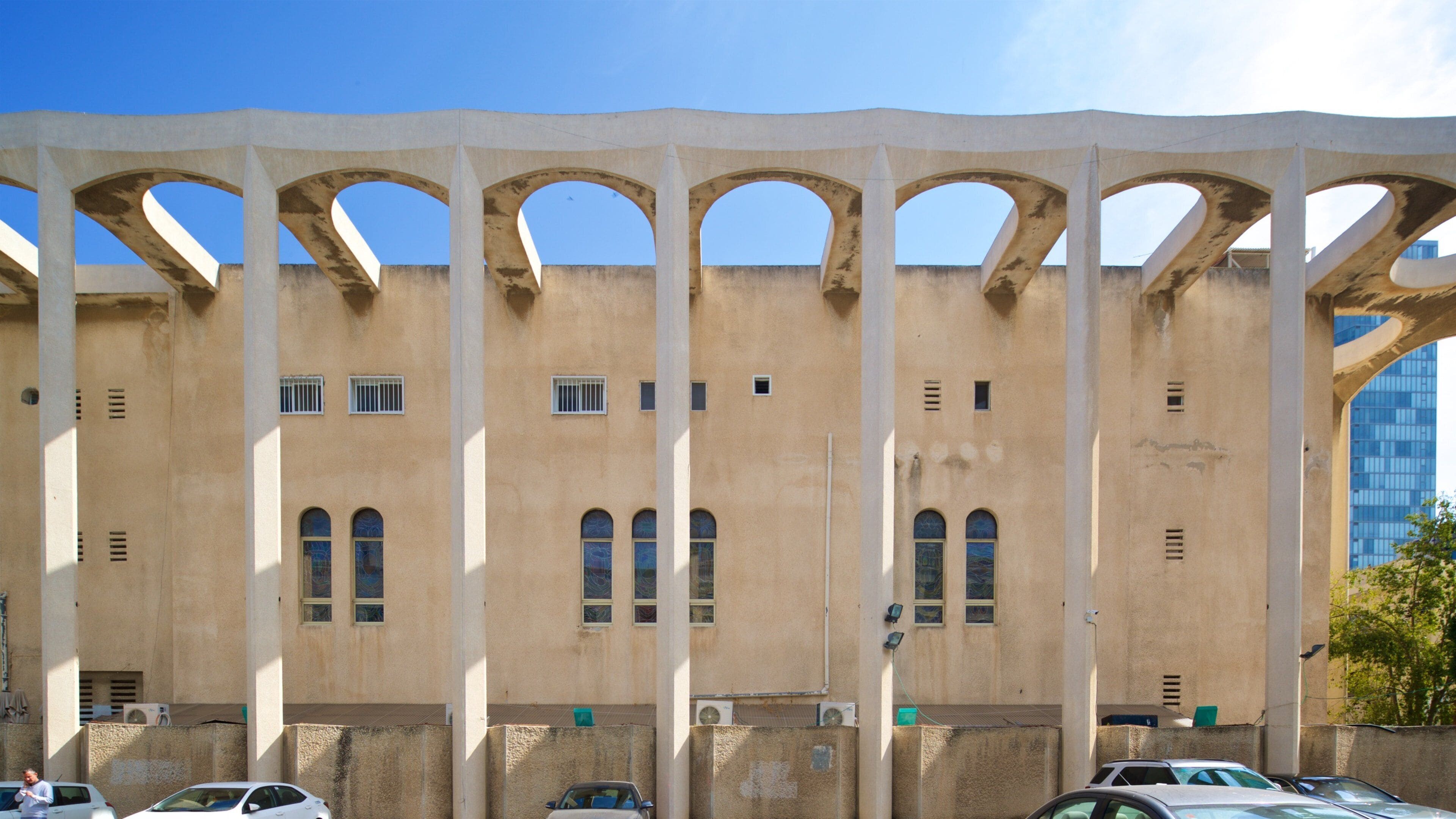 Um edifício grande com várias janelas em arco e uma série de colunas.