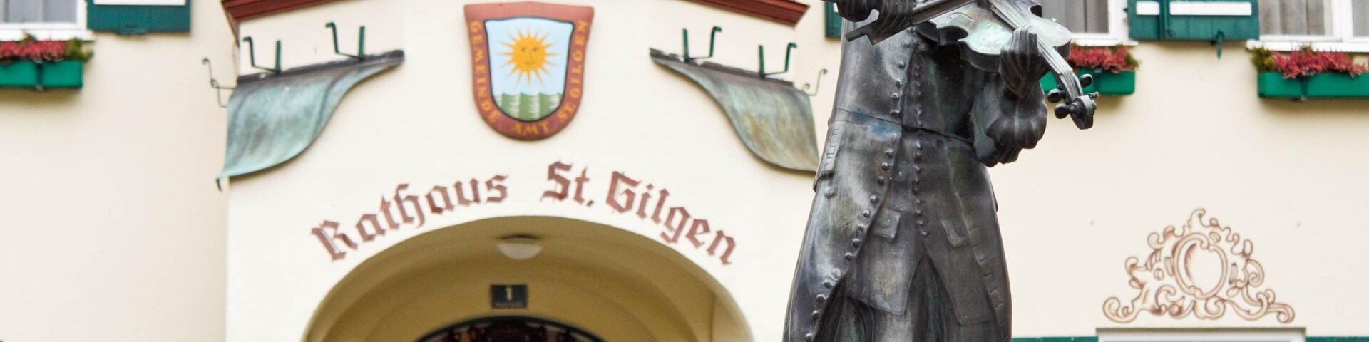 Statue of young Wolfgang Amadeus Mozart in front of townhall on Mozartplatz in St. Gilgen, Austria