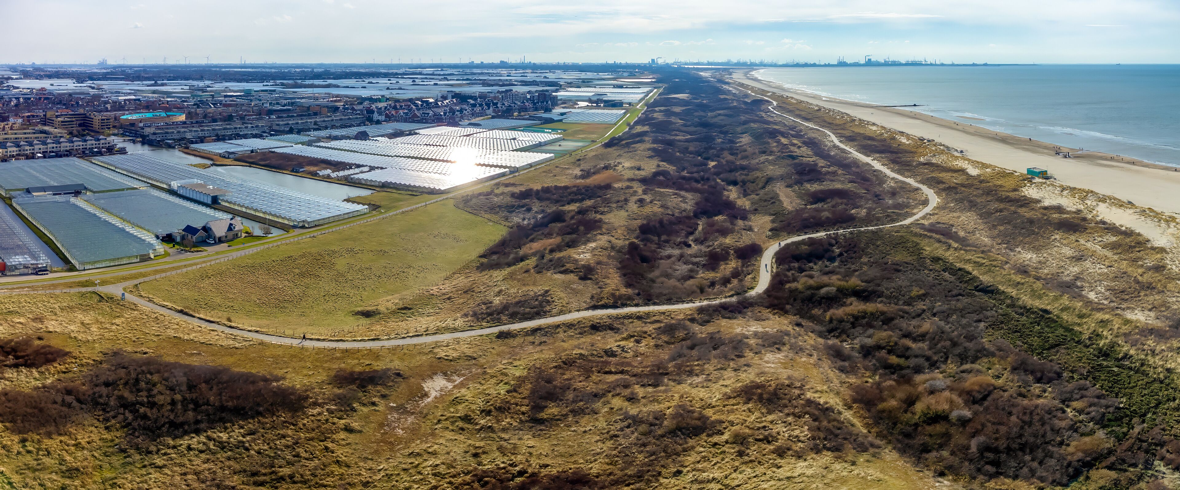 Panorama view of the dunes, beach, and the Westland greenhouses seen from above from the little village Ter Heijde aan Zee in the Netherlands.