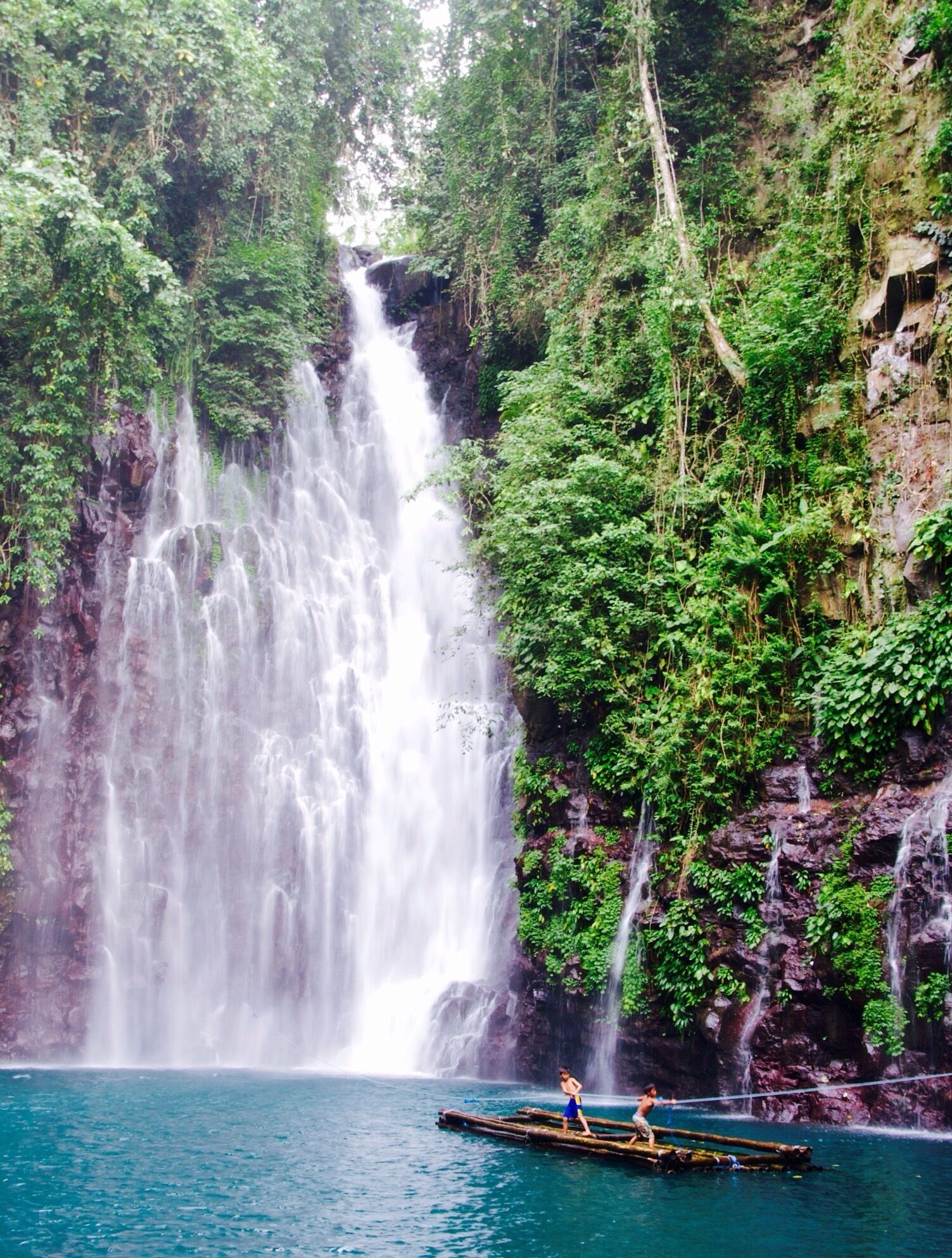 It's Tinago Falls this time! The word "tinago" means hidden. And yes, literally, it is hidden. It sits in the middle of the woods. There are two ways to get here. First is taking the 400-step stairs and the other is the 200-step stairs. No matter which way you choose, both are immensely EXHAUSTING! Whew! Just because it's only 200 steps does not mean it's easier than the former. It's a broken trail! The concrete stairs have been ruined by roots of old trees and plants, which make your journey even harder. Not to mention the cliff where you can fall off from if you don't watch out.

Let me talk about the mystery behind this (I'm thrilled as I begin): the truth is that no one has ever measured the depth of this yet. Many people attempted to do so, but they ended up losing their lives. Locals of this place say that there are "beings" that live underwater and that they take lives every now and then. No one knows whether that is true or not. It's a hearsay. All I know is that Tinago Falls remains a mystery to the world. Below the rock formations are caves. And just behind that water curtain lies another cave. And then a few more everywhere. A number of people has seen it, but it required them first an immeasurable amount of courage before they were able to do see the caves. The last time I came here, I got a chance to talk to a 23-year old guy who lives around. He claimed to be one of the caretakers of the falls. He recounted several stories he has witnessed over time, such as hearing cries all over the place very early in the morning, seeing a friend of his jump off from the top and died head-on; and looking at people risk their lives by trying to swim deep down (then they never came to the surface ever again).

The falls is overwhelming. Even I cannot stop staring at it despite having seen it already a thousand times in my life. I've heard that an aerial perspective of the lagoon/falls will you give you an image of just plain dark water. It may have appeared blue-green in the picture but from afar, it is black. Nonetheless, this place is best known for its relaxing atmosphere. The water is very cold -- so ideal for tropical countries like ours, especially during summer. People come here for picnics and picture-taking activities. I love this place. I can go on talking about it for hours. By the way, I've taken several friends here and they all said the same thing: "WOW!" I hope to also see this wow-expression on your face one day. You are most welcome in my city.

Happy travels,
Star, Iligan City, PH