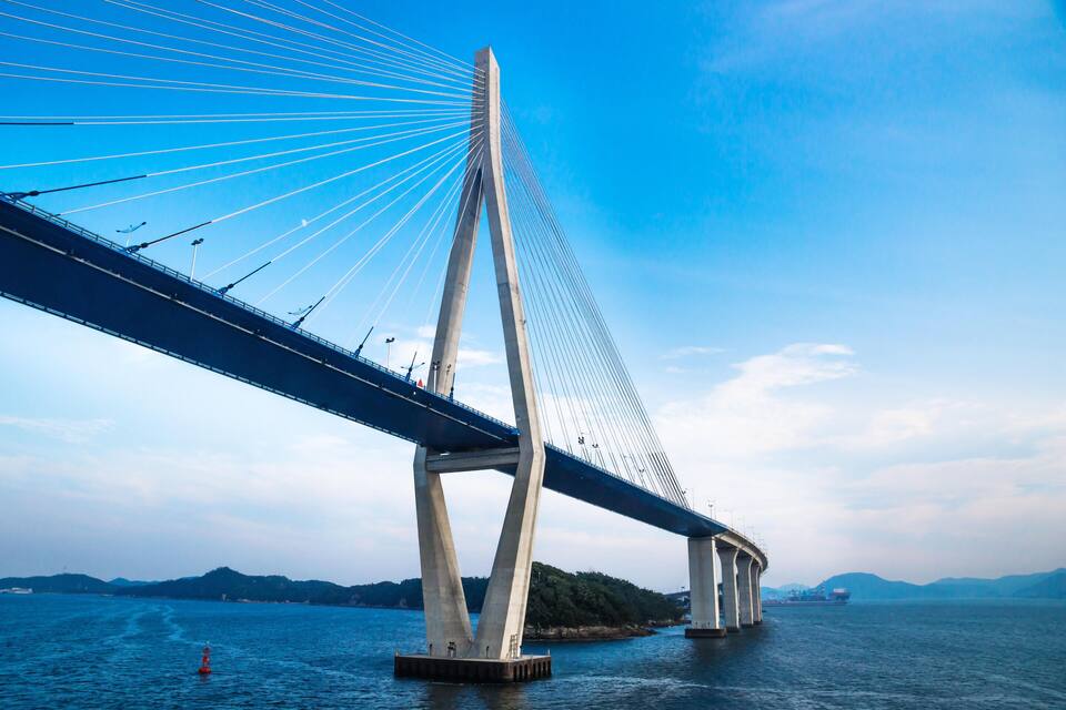 A large suspension bridge with tall towers and cables spanning a body of water.
