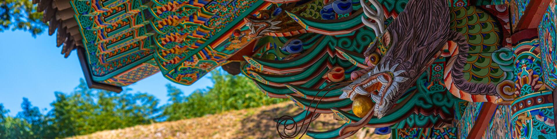 Un tejado tradicional detallado con patrones intrincados y la figura decorativa de un dragón.