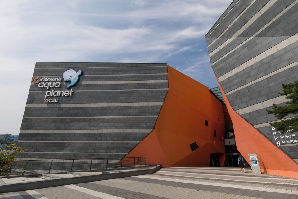A modern building with a large whale logo and the text 'Hawaii Aquatic Planet Yeosu'.