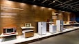 A museum exhibit of vintage electronics from the 1970s and 1980s, including TVs, microwaves, and refrigerators.