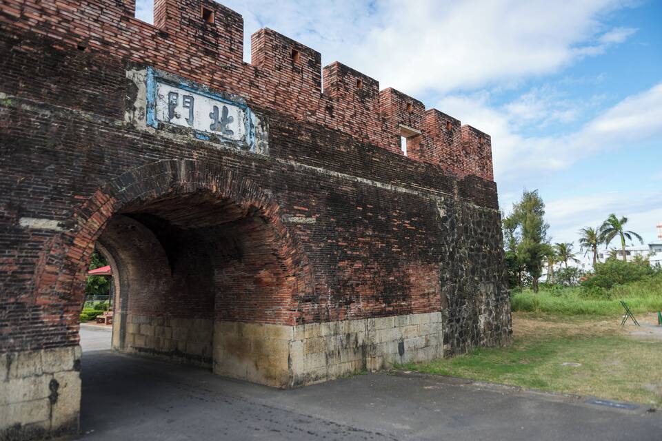 An old brick bridge with a sign and a small archway.
