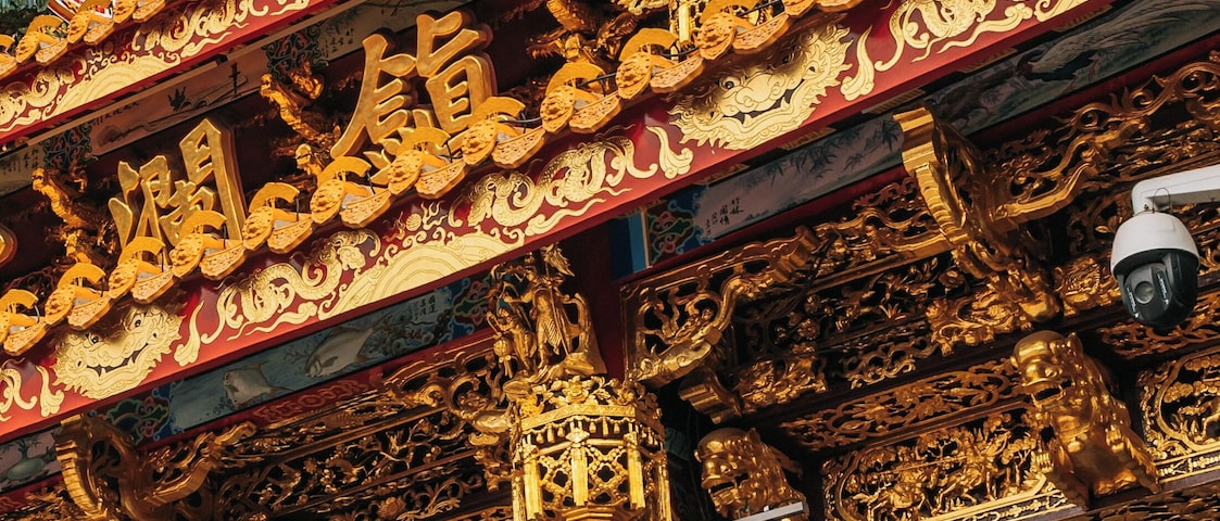 Um templo tradicional chinês com decoração dourada elaborada e esculturas de dragões.