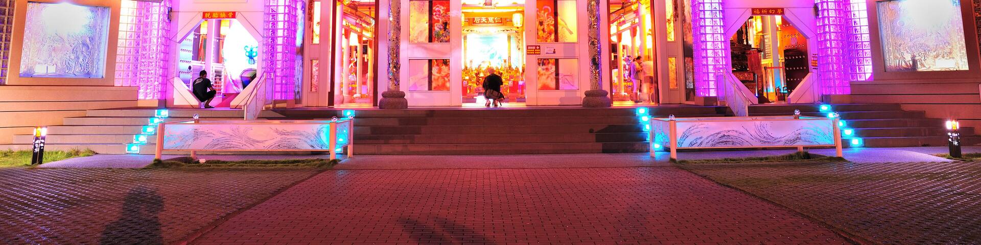 A traditional Chinese building with illuminated structures at night.