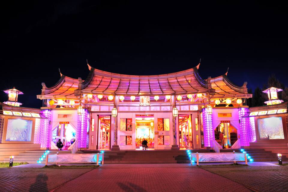 A traditional Chinese building with illuminated structures at night.