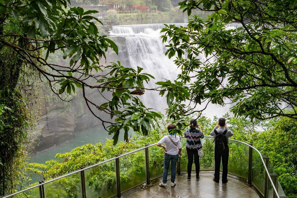 A waterfall with a metal railing.