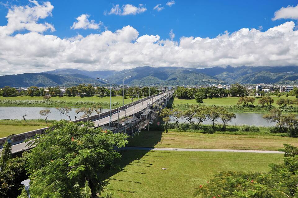 A bridge over a river with mountains in the background.