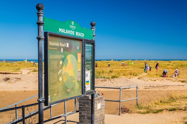 Ein Schild am Strand von Malahide mit Informationen zum Strand.
