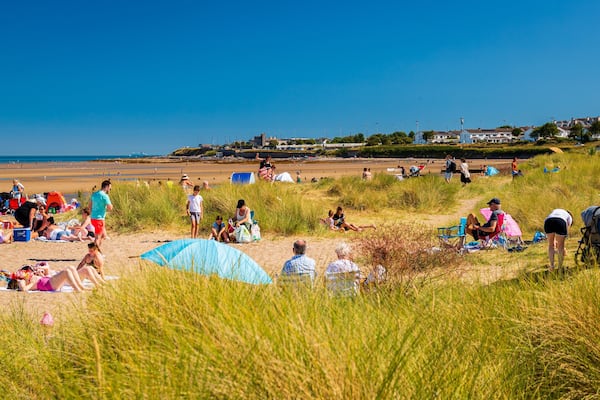 Malahide Beach showing a beach and general coastal views as well as a large group of people
