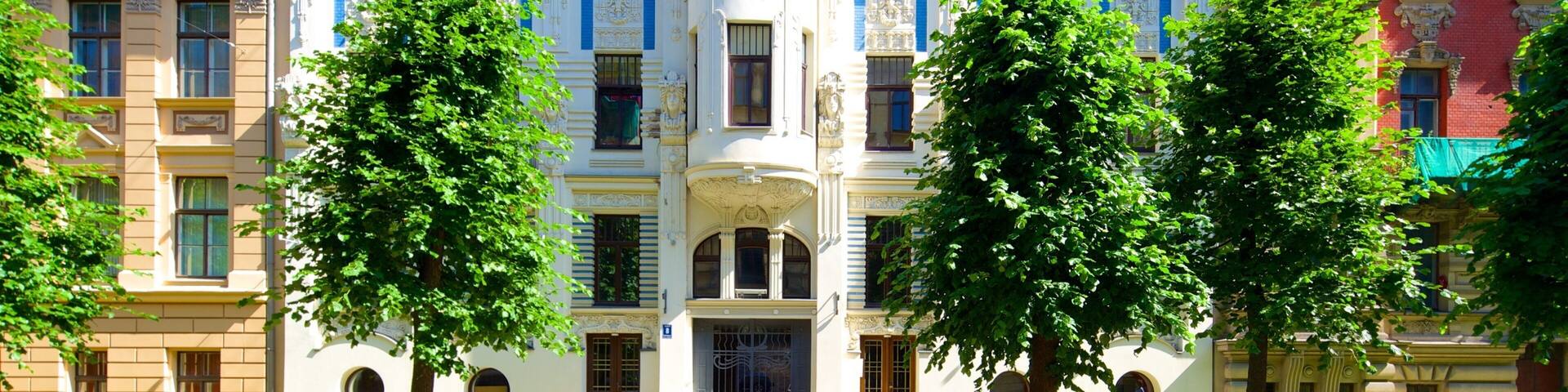 Un edificio histórico con arquitectura ornamentada, ventanas grandes y una entrada central.