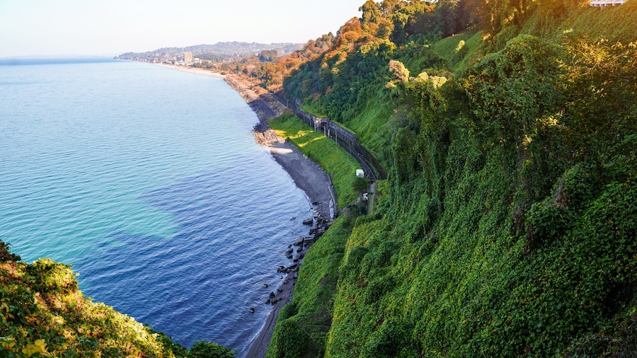 Beautiful, bewitching view of the blue sea, green cape and the railway from the botanical garden in Batumi Georgia in clear sunny day