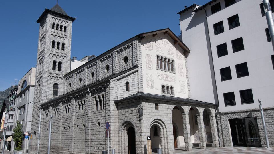 A historic stone church with a bell tower and arched windows.
