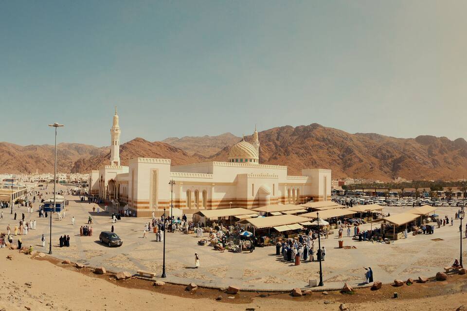 Une mosquée dotée d’un minaret et d’une vaste cour entourée de montagnes.