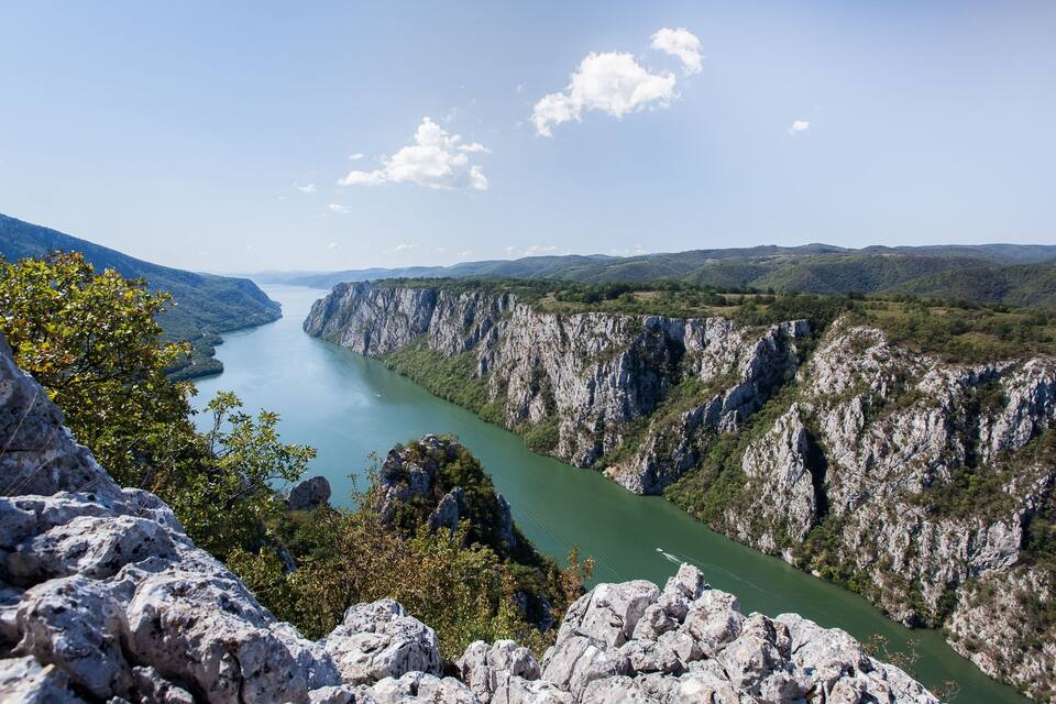 Un canyon traversé par une rivière, avec des falaises abruptes et un ciel dégagé.