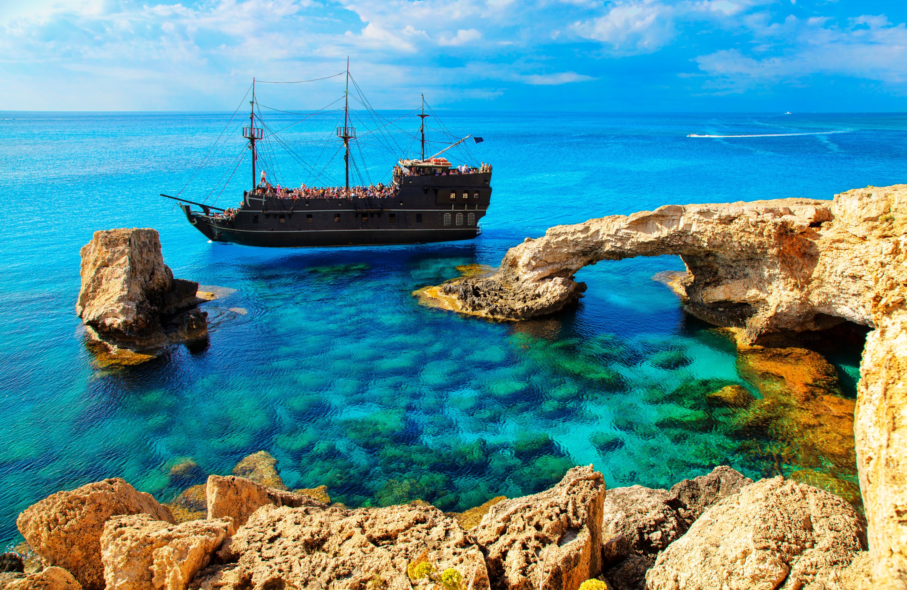 The bridge of love or love bridge. Pirate ship sailing near famous Bridge of Love near Ayia Napa, Cyprus.