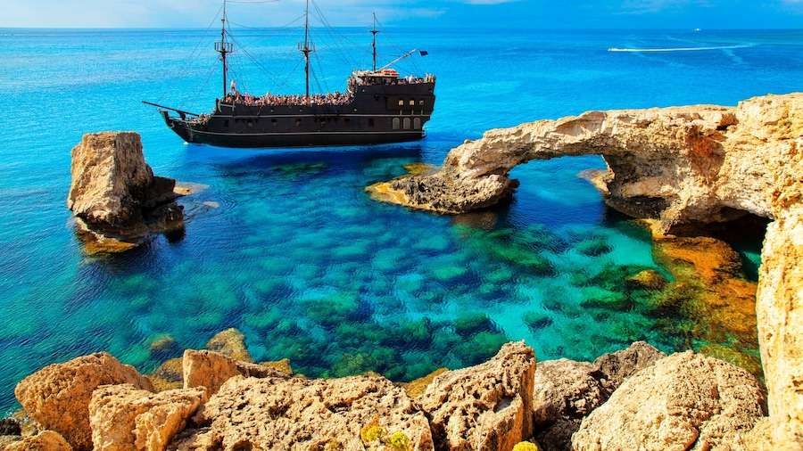 The bridge of love or love bridge. Pirate ship sailing near famous Bridge of Love near Ayia Napa, Cyprus.