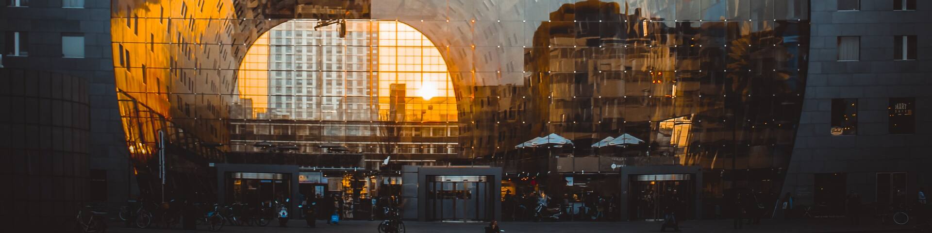 Reflection of cityscape in Rotterdam on the facade of Market Hall (Markthal) during golden hour