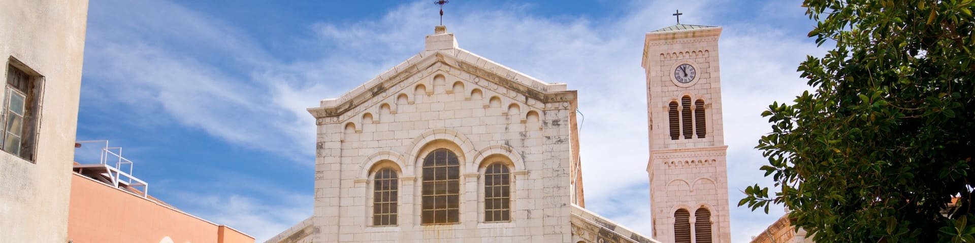 Una iglesia histórica con un campanario y ventanas de arco.