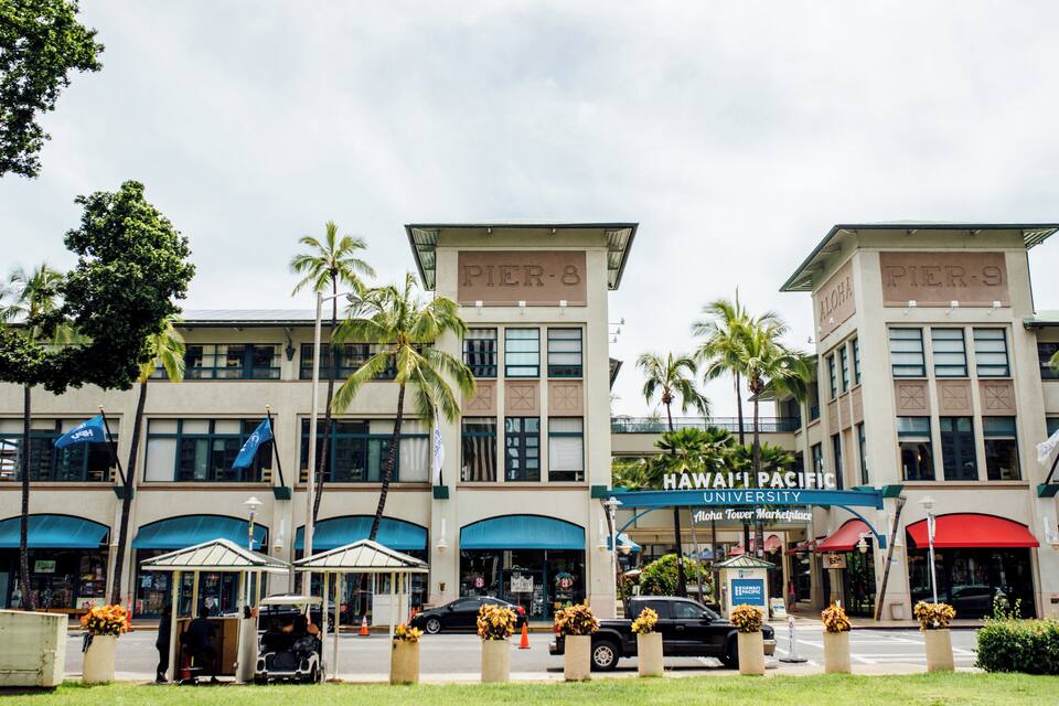 Un bâtiment sur lequel on peut lire les inscriptions « Pier-8 » et « Pier-9 », ainsi qu’une enseigne indiquant « Hawai’i Pacific University ».