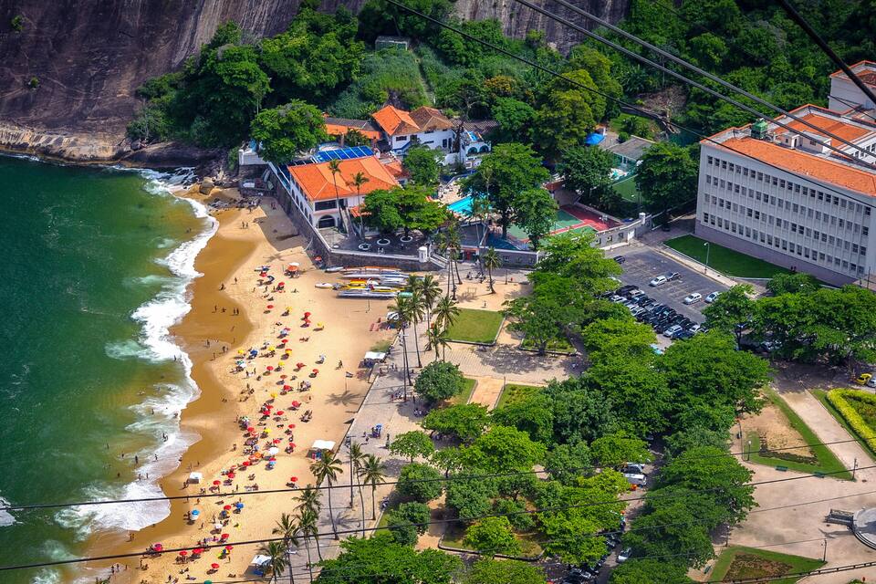 Une ville côtière avec une plage, des bâtiments et une statue.