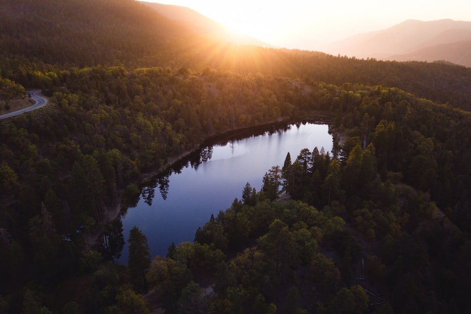 Un lago rodeado de bosque denso y montañas.