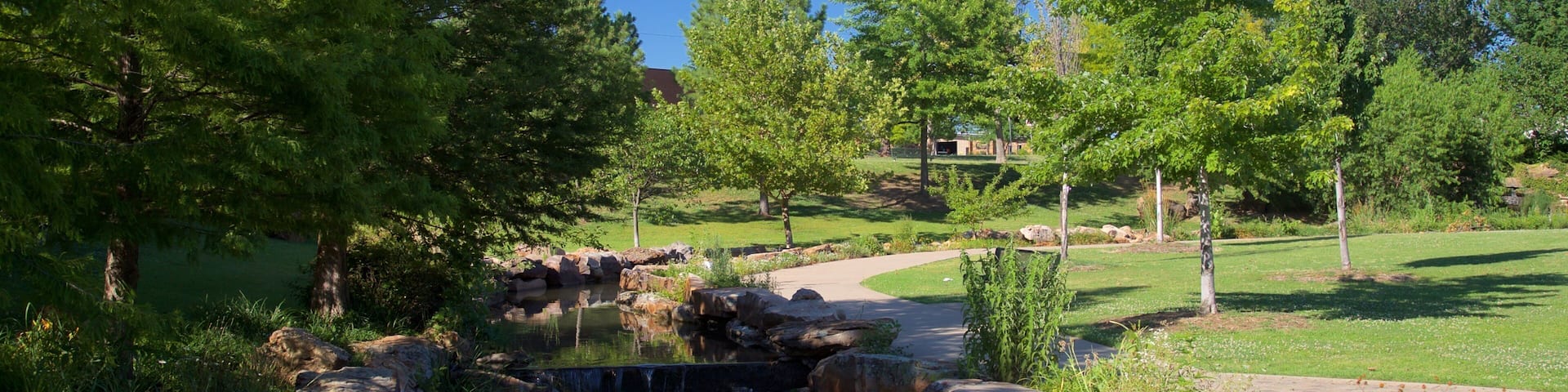 Parque del Centenario que incluye un jardín y un río o arroyo