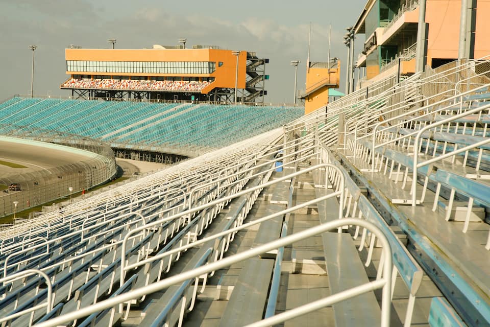 A large, empty stadium with blue and white seating.