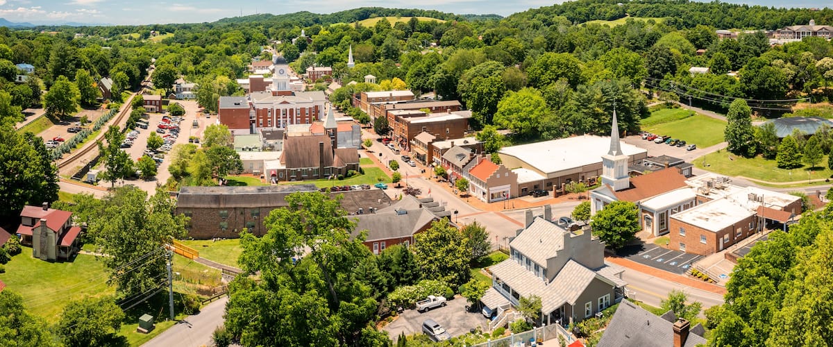 A town with a central square, historic buildings, and surrounding greenery.