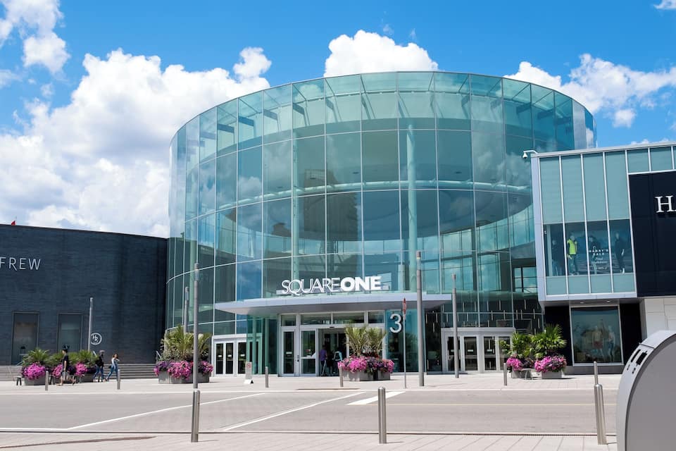 A modern glass building with the sign "SQUARE ONE" and a number "3" on the entrance.