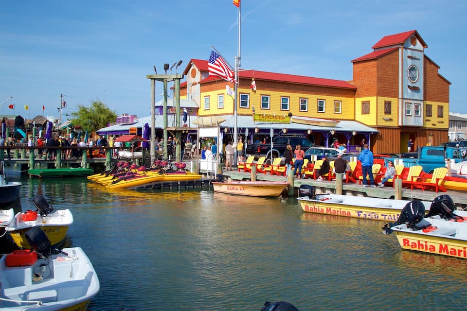 Un port de plaisance avec des bateaux aux couleurs vives, un restaurant appelé Tackleshop et un bateau de la marque Bahia Marina.