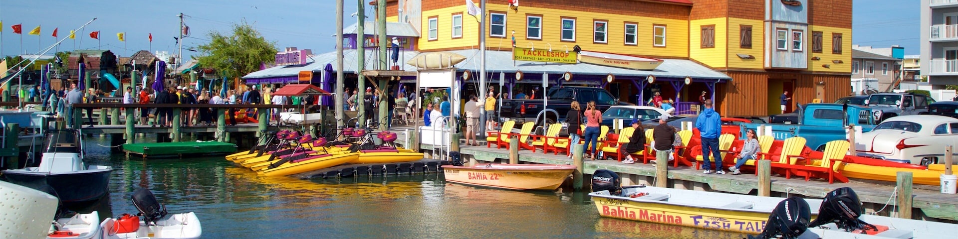 Uma marina com barcos coloridos, o restaurante Tackleshop e um barco da Bahia Marina.