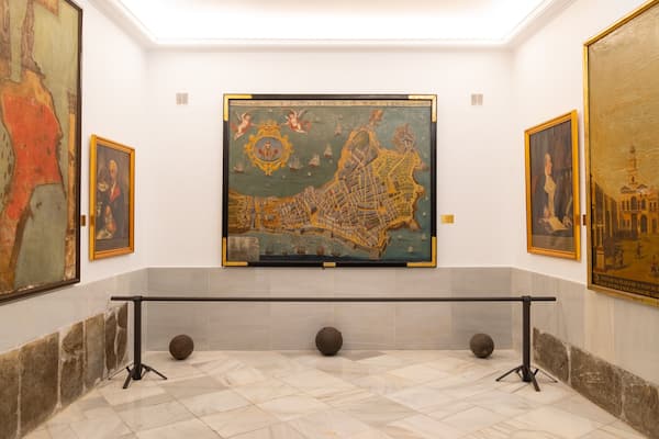 Eine Galerie mit großformatigen historischen Gemälden und einem Marmorboden.