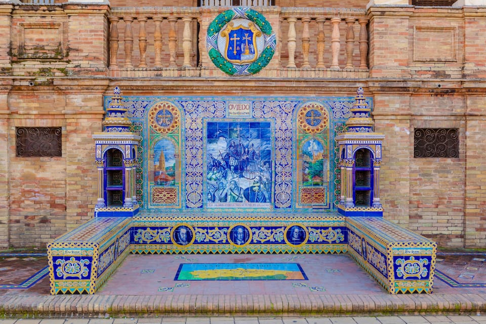 A tiled altar with intricate blue and gold designs, a central mosaic, and a circular emblem above.