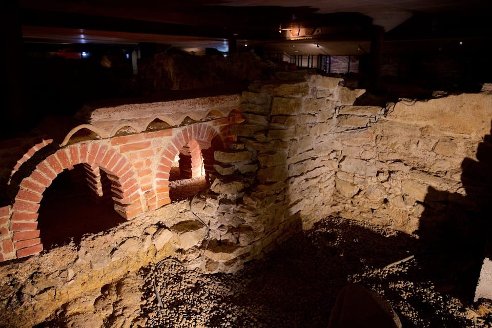 Una antigua estructura de piedra con un arco de ladrillo.