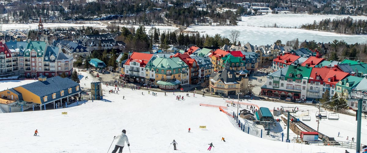 A snowy ski resort with colorful buildings and a ski slope.