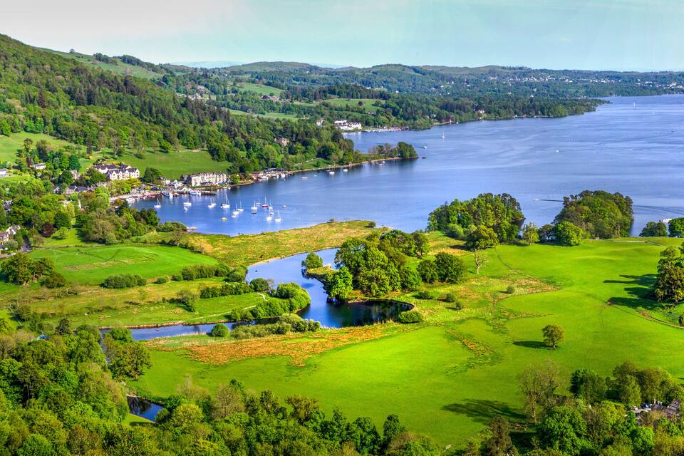 A coastal town with a marina, green fields, and a river.